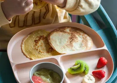 Enfant mangeant des crêpes avec fruits