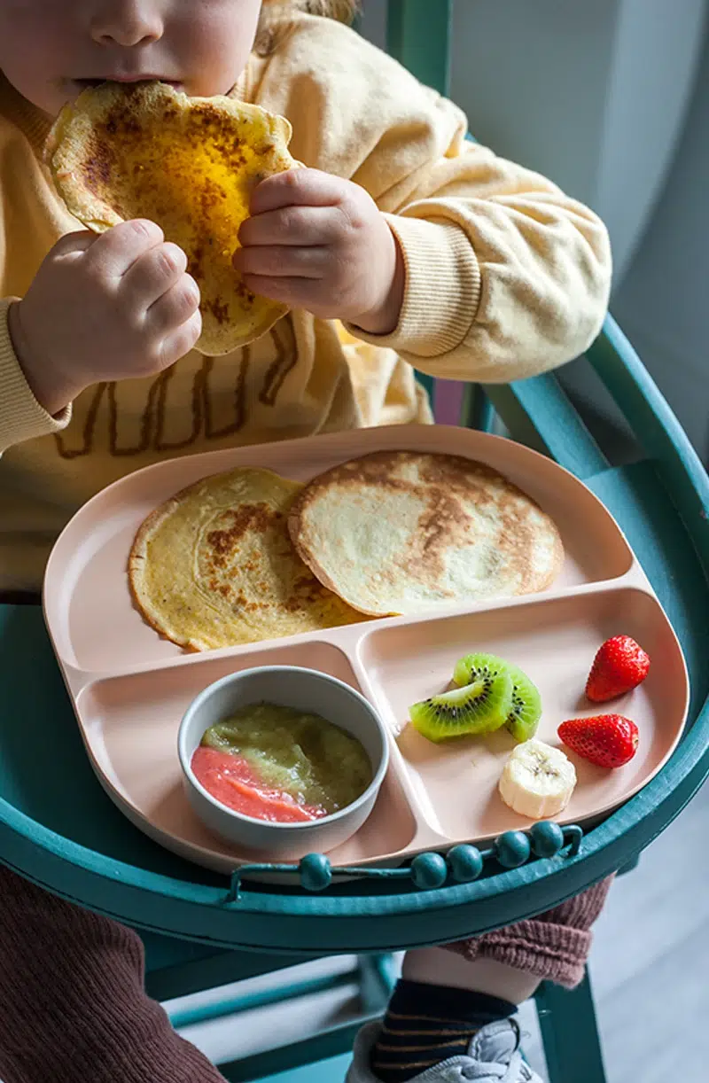 Petit-déjeuner enfant avec crêpes et fruits Enfant mangeant des crêpes avec fruits