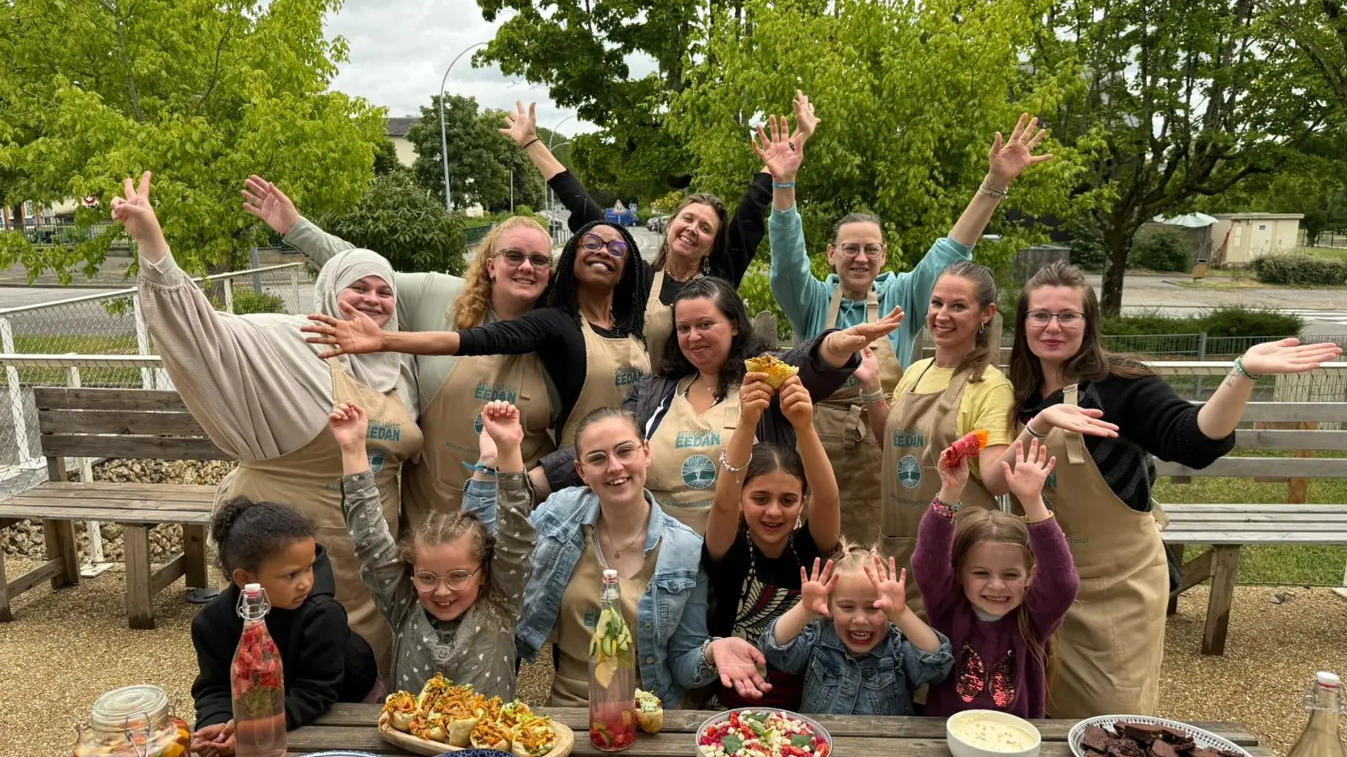 Atelier culinaire en plein air Groupe de personnes souriantes avec des plats